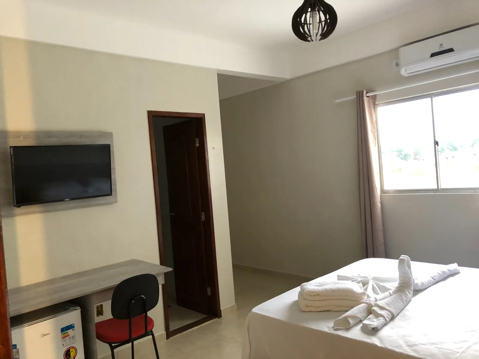 Quarto com cama de casal, TV, frigobar e ar-condicionado